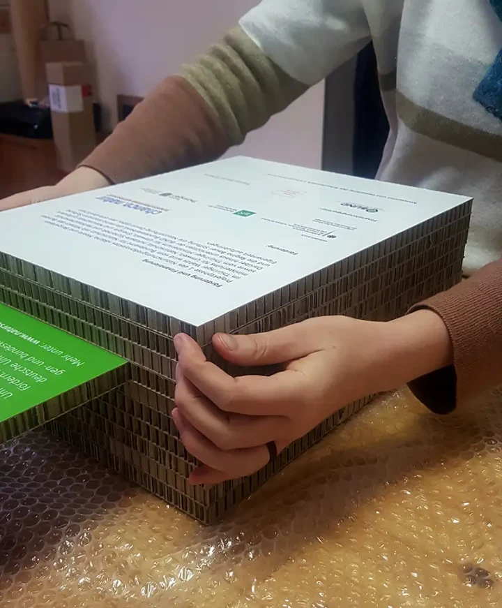 Wabenpappenelemente werden händisch aufeinander geschichtet.