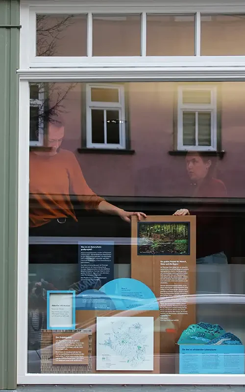 Nele und Melissa stehen hinter der aufgebauten Schaufensterausstellung.