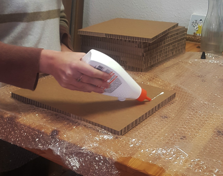 Leim wird auf Wabenpappe aufgetragen.