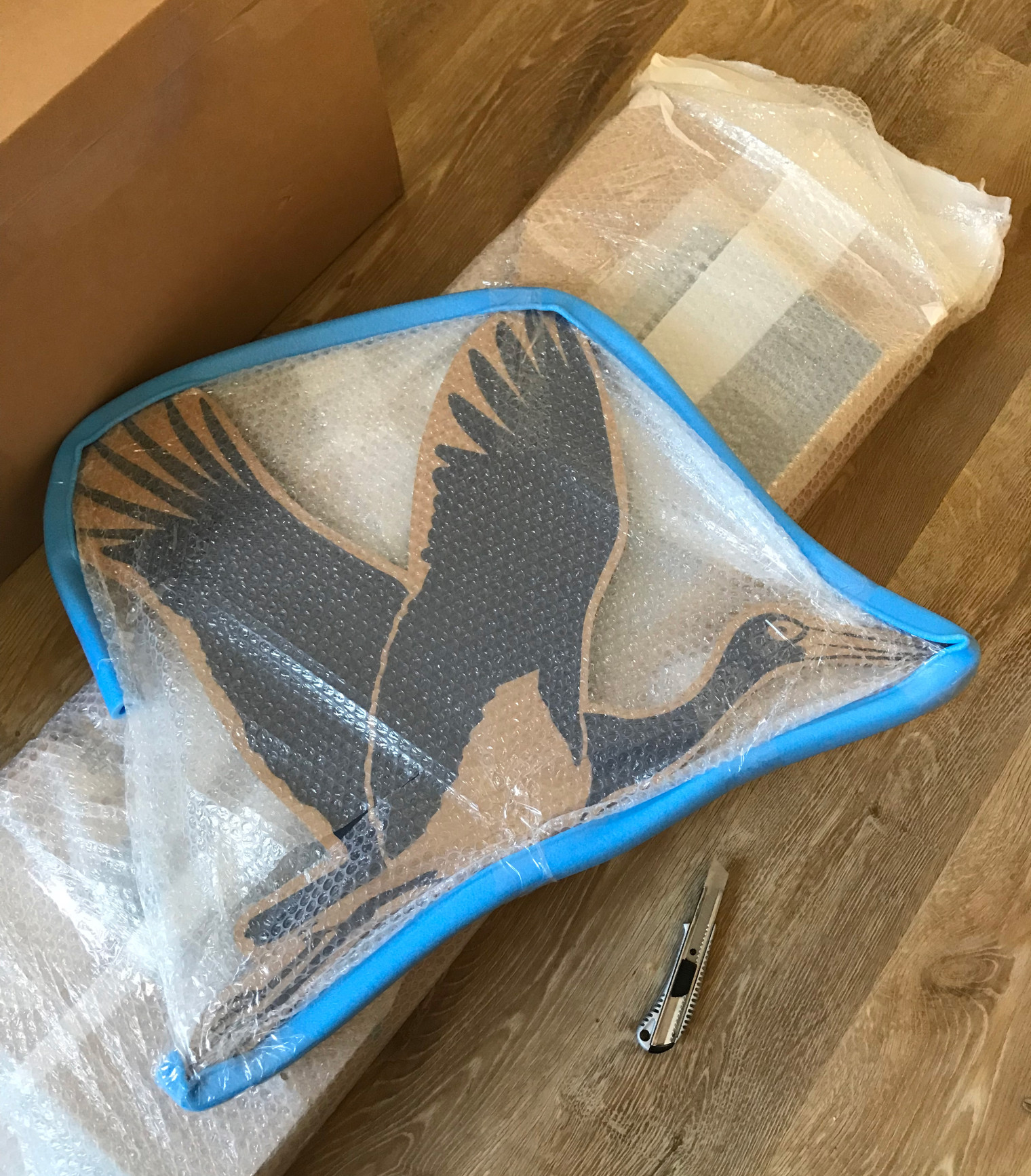 In Luftpolsterfolie verpackte Wabenpappe mit aufgedrucktem Schwarzstorch.