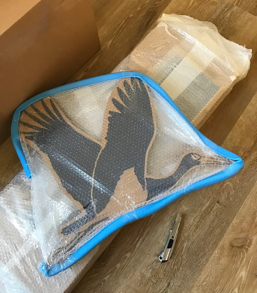 In Luftpolsterfolie verpackte Wabenpappe mit aufgedrucktem Schwarzstorch.